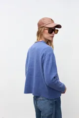 Sweater de punto en color azul, con cuello redondo y diseño clásico de manga larga.