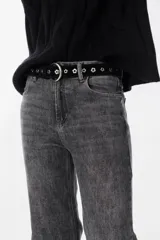 Cinturón de cuero negro con diseño de ojales en forma de flor y hebilla metálica plateada de media luna.