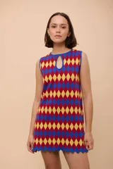 Vestido corto sin mangas con estampado de rombos en azul, rojo y amarillo. Tiene escote con forma de gota y terminación en picos.