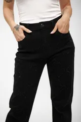 Jean de corte recto color negro, con diseño de rombos formados por pequeños brillos o tachas aplicadas en toda la prenda.