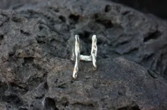 Anillo plateado con diseño abstracto y abierto, realizado en alpaca.