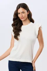 Remera tejida de algodón en color beige, de cuello redondo, sin mangas y con detalles de volados estructurados en los hombros.