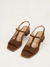 Sandalias de cuero marrón, con taco cuadrado bajo, puntera cuadrada abierta y diseño en T con tira ajustable con hebilla en el empeine y tira en el talón.