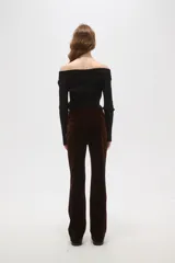 Pantalon de corte flare y tiro alto, confeccionado en tejido de pana color marrón oscuro, con cierre frontal y bolsillos laterales.