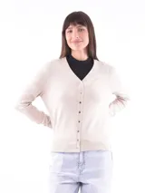 Saco de tejido de punto color beige, con cuello en V y cierre frontal con botones.