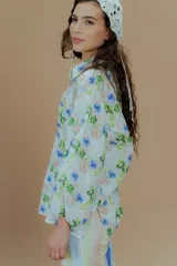 Camisa de lino con cuello clásico y mangas abullonadas, con estampado de rayas verticales en tonos pastel y azul vibrante.