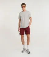 Bermuda deportiva para hombre de color bordó, con cintura elástica con cordón de ajuste, bolsillos con cremallera y recortes laterales con perforaciones láser.