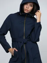 Campera softshell de color azul marino, con capucha, cierre frontal y cinturón anudable a la cintura. Presenta bolsillos laterales y un diseño funcional resistente al viento y al agua.