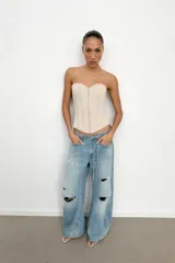 Top tipo corset de escote corazón y hombros descubiertos, con varillas interiores para estructura. Presenta cierre frontal con ganchos metálicos y ajuste en la espalda mediante cordones cruzados.