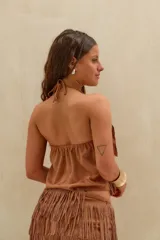 Top halter marrón con diseño de capas de flecos, cuello alto y espalda descubierta.