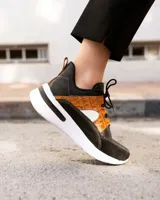 Championes deportivos de cuero en tonos marrón, tostado y marrón oscuro, con detalles de estampado animal print de leopardo en el lateral, suela gruesa blanca y cordones elásticos.