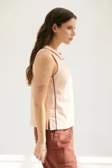 Musculosa blanca de lino con cuello redondo y ribete marrón.