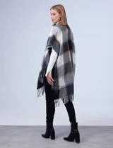 Kimono de tejido suave con diseño a cuadros en tonos blanco, negro, gris y beige. Presenta flecos en el borde inferior.