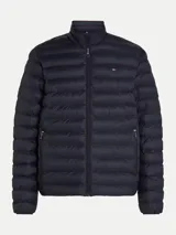 Campera puffer Tommy Hilfiger color azul marino, con cuello alto, cierre frontal con cremallera, bolsillos laterales con cremallera y logo bordado en el pecho.