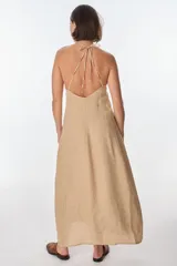 Top largo marrón con breteles finos ajustables y tajo frontal. Confeccionado en lino italiano.