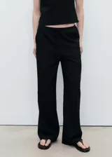Pantalón negro de tiro medio con cintura elástica y lazo ajustable, de diseño recto.