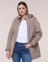 Campera larga color tostado con diseño capitoneado geométrico y capucha desmontable con cordón de ajuste. Cuenta con cierre frontal completo, bolsillos laterales con cierre y detalle de ajuste en la cintura.