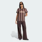 Camiseta de fútbol Adidas de manga corta, color marrón con diseño de rayas verticales oscuras. Presenta cuello polo con escote en V, el logo clásico de la marca bordado en el pecho junto con la inscripción "adidas" en gran tamaño al frente, y las franjas características de la marca en los hombros.
