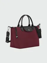 Cartera de mano modelo Le Pliage Energy de Longchamp, tamaño pequeño. Confeccionada en lona de color bordó con detalles en cuero negro, incluyendo solapa con cierre de botón a presión y asas. Incluye correa ajustable y extraíble de tejido técnico negro.