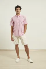 Camisa sport de manga corta, confeccionada en una mezcla de lino y algodón. Presenta cuello clásico, cierre frontal con botones de coco y un bolsillo aplicado en el pecho.