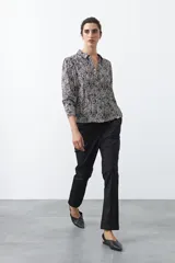 Pantalón de vestir negro de corte recto, con cintura estructurada y costura central vertical en las piernas que aporta un acabado sastrero.