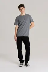 Jean de corte slim fit en color negro, confeccionado en denim rígido. Presenta cierre de botón y cremallera, con diseño clásico de cinco bolsillos y tiro medio.