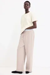 Remera color crema de corte recto en punto suave de algodón con cuello redondo ribeteado y hombros ligeramente caídos.