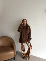 Pantalón de corte oxford con estampado geométrico abstracto en tonos marrones, beige y negro. Presenta una silueta ajustada en la parte superior y acampanada en el ruedo.