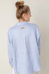 Camisa de lino color gris claro con bordado de monograma PEC en el bolsillo.