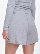 Short de dormir de punto pointelle color blanco, con cintura elastizada y cordón de ajuste frontal.