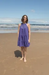 Vestido corto de corte holgado con escote halter adornado con detalles de crochet tejido. Presenta un diseño escalonado con volados en la falda.