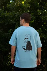 Remera celeste de algodón con estampado en la espalda de un perro con gafas de sol sosteniendo una copa y la palabra 'MOOD'.