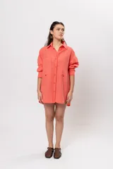 Camisa larga amplia color coral con patrón a cuadros, cuello camisero, cierre frontal con botones y grandes bolsillos en el pecho.