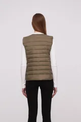 Chaleco acolchado color verde militar con cierre de botones a presión.