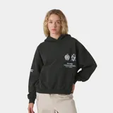 Hoodie oversize color negro con capucha y bolsillo canguro. Estampado frontal en blanco con dos escudos y texto que dice "MADRID HEADQUARTERS WORLD GOLF FEDERATION".