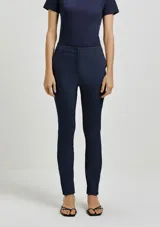 Pantalón sastrero de corte recto y ajuste entallado, con cintura de tiro medio, cierre frontal con botón y bolsillos laterales.