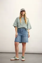 Remera color crema de corte holgado, con mangas cortas y costuras a la vista en color ocre.