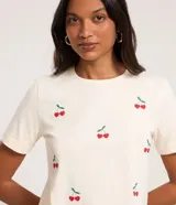 Remera color crema de algodón con bordados de cerezas rojas y hojas verdes.