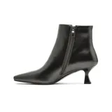 Bota corta de vestir color negro, con punta cuadrada y taco bajo tipo kitten heel. Presenta un diseño minimalista con cierre lateral interno.
