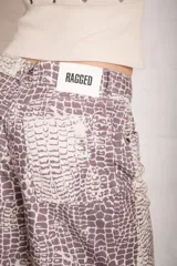 Pantalón de jean de corte ultra baggy y holgado, con pierna ancha, tiro bajo y estampado de efecto cocodrilo.