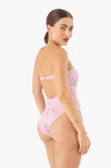Traje de baño enterizo color rosa con textura arrugada, corte bandeau, herrajes dorados y copas extraíbles.