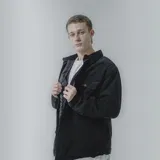 Campera color borgoña de pana con cuello camisero, cierre frontal con botones a presión y dos bolsillos de parche en el pecho. Interior acolchado con patrón de rombos.