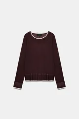 Jersey de punto efecto doble, color bordó con detalles en color crema en el cuello, puños y ruedo. Presenta cuello redondo y mangas largas con diseño de hombros raglán.