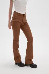 Pantalon de corte flare en color negro, con acabado engomado, tiro medio y cierre frontal con botón y cremallera.