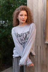 Buzo de cuello redondo gris melange con estampa frontal en negro con la frase "happy is the new rich".