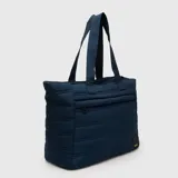 Tote bag acolchada de color azul marino, con diseño de costuras horizontales, doble asa superior y bolsillo frontal con cierre. Incluye compartimento interno para laptop.