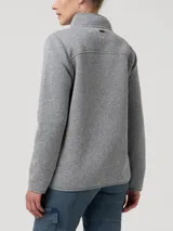 Campera polar de fibras recicladas color gris melange, marca RKF, con cuello alto, cierre frontal completo y bolsillos laterales y en el pecho con cierre.