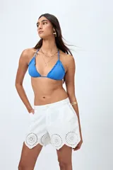 Short blanco de algodón con bordado calado y terminación festoneada en el borde inferior.