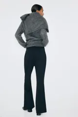 Pantalón en punto pesado de tiro alto, color negro, con elástico oculto en la cintura, cierre y pretina prolongada con corchete oculto. Piernas bootcut con raya cosida.