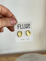 Caravanas irregulares hechas a mano en bronce, de aproximadamente 1 cm de diámetro, con un acabado dorado.